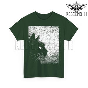 May include: A dark green short-sleeve t-shirt featuring a white graphic print of a cat profile silhouette against a textured background. The text REBELMOTH is printed in the upper right corner and across the center of the shirt in a serif font.