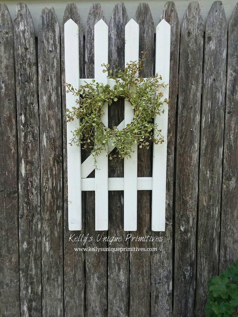 Give your fence a nice cottage look by adding rustic materials to it. Try a flower box, window frame, wreaths or other cottage decor. I think this is my favorite look! Here are some quick and easy ways to decorate your garden fence. 