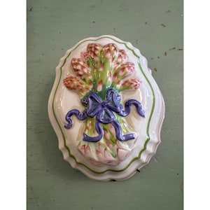 May include: A white ceramic mug with a black handle and the text "But First, Coffee" in a black, handwritten-style font. The mug is on a white surface.