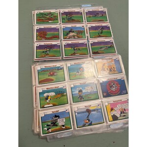 Könnte beinhalten: Eine Sammlung von Baseball-Sammelkarten mit Cartoon-Charakteren in verschiedenen Baseball-Szenen. Die Karten befinden sich in Schutzhüllen und sind in einem Ordner organisiert. Die Karten haben farbenfrohe Illustrationen und Text.