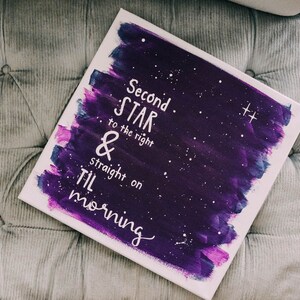 May include: A purple and blue canvas painting with white stars and the text "Second Star to the right & straight on til morning".