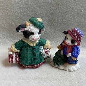 Mary&#39;s Moo Moos Figurines - Cow w/ Packages (&#39;Shop Til the Cows Come Home&#39;) and Cow w/ Tree (&#39;A Bright Future for Moo&#39;) -Set of 2 (#FIG1175)
