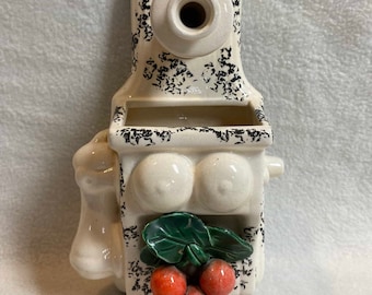 May include: White ceramic wall planter shaped like a vintage phone with black speckles. The planter has a small opening at the top and a larger opening in the front. A green leaf and three red cherries are attached to the front of the planter.