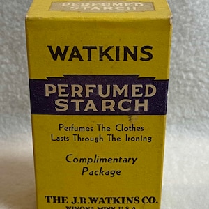 May include: A yellow box with black text that reads "Watkins Perfumed Starch". The box has a purple border around the text. The text below the product name reads "Perfumes The Clothes Lasts Through The Ironing Complimentary Package". The bottom of the box reads "The J.R. Watkins Co. Winona, Minn. U.S.A."