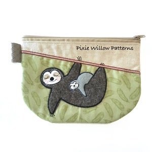 May include: A beige zippered pouch with a brown sloth and a baby sloth hanging from a branch. The pouch has a green background with a pattern of leaves. The text "Pixie Willow Patterns" is printed on the pouch.
