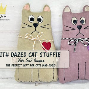 May include: Two stuffed cat toys. One is tan with a red heart, the other is mauve with a purple heart. Both have embroidered faces, whiskers, and bows. The text on the image reads "ITH DAZED CAT STUFFIE For 5x7 hoops".