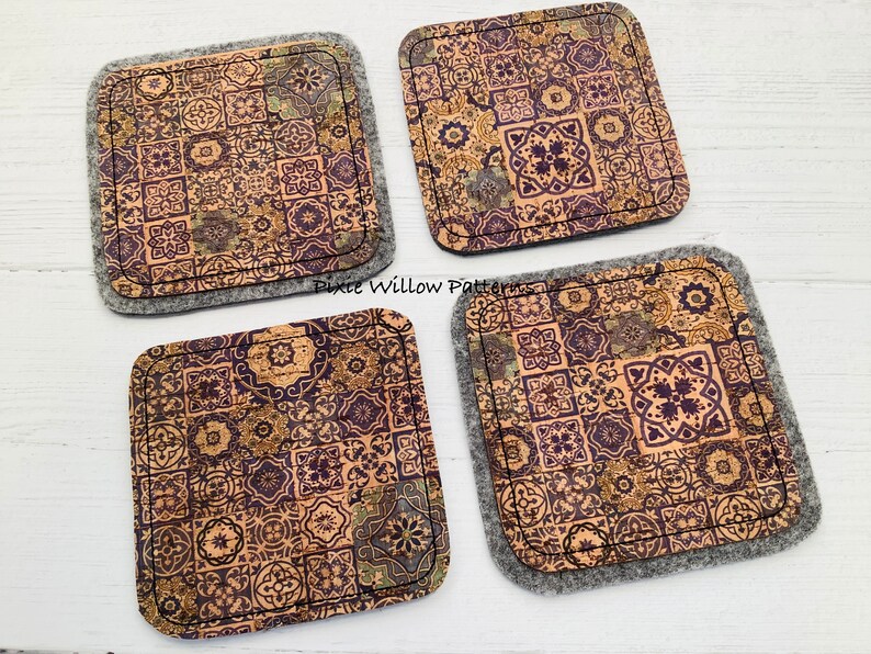 May include: Set of four cork coasters with a patterned design of brown, gold, and purple tiles. The coasters are backed with gray felt.