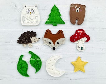 Puede incluir: Parches de aplique de fieltro con animales del bosque, un hongo, un árbol, hojas, una luna y una estrella. Los parches son de varios colores, incluyendo marrón, blanco, verde, rojo y amarillo.