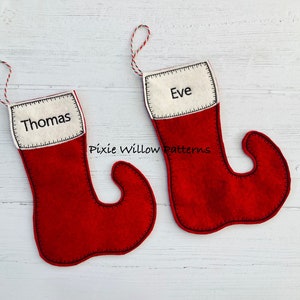 May include: Two red felt Christmas stockings with white fabric tops and black stitching. The stockings are personalized with the names "Thomas" and "Eve".