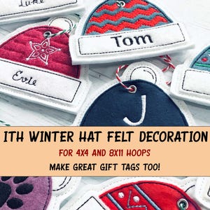 Op de afbeelding: Vilt wintermutsdecoraties in verschillende kleuren, waaronder rood, blauw en groen, met witte naamlabels. Elke hoed heeft geborduurde details en een touwtje om op te hangen. De tekst luidt "ITH WINTER HAT FELT DECORATION".