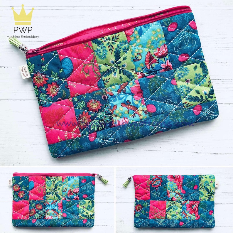 May include: A pink and blue patchwork zippered pouch with a floral pattern. The pouch is quilted and has a pink zipper.