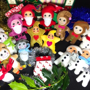 May include: A collection of handmade Christmas ornaments, including Santa Claus figures, gingerbread people, stars, snowmen, and monkeys. The ornaments are made of felt and fabric, with embroidered details and cheerful expressions. Festive decorations include tinsel and holly.
