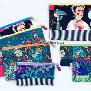 Op de afbeelding: Een set van zes kleurrijke ritszakjes met verschillende bloemen- en Frida Kahlo-ge&iuml;nspireerde ontwerpen. De zakjes zijn gemaakt van stof en hebben een zwart-wit gestreepte onderkant. De tekst "Pixie Willow Patterns" is zichtbaar op een van de zakjes.