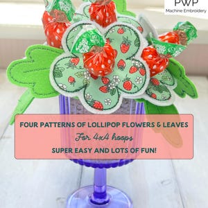 Peut inclure: Une composition fantaisiste de fleurs et de feuilles de sucettes dans un verre violet. Les fleurs sont en feutre vert et tissu à motif de fraises, les sucettes sont emballées en rouge et vert. Le texte sur l'image dit : "FOUR PATTERNS OF LOLLIPOP FLOWERS & LEAVES For 4x4 hoops SUPER EASY AND LOTS OF FUN!"
