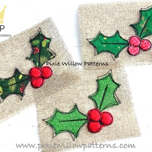 Könnte beinhalten: Drei gestickte Stechpalmenzweige mit roten Beeren auf einem Jutestoff-Hintergrund. Die Zweige sind grün mit schwarzem Umriss und haben ein gepunktetes Muster. Der Text "Pixie Willow Patterns" ist unter den Zweigen sichtbar.
