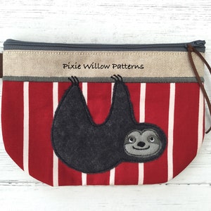 Puede incluir: Una bolsa con cremallera con un patrón de rayas rojas y blancas, con una aplicación de perezoso gris. La sección superior es beige con el texto "Pixie Willow Patterns". Una cremallera de cuero marrón está unida a la cremallera.