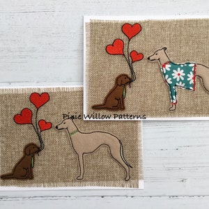 Op de afbeelding: Twee wenskaarten met hondenillustraties. Eén kaart toont een bruine hond die rode hartballonnen vasthoudt, tegenover een windhond. De andere kaart heeft een vergelijkbaar ontwerp, waarbij de windhond een jas met bloemenpatroon draagt. De kaarten staan op een jute achtergrond.