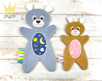 May include: Two plush toy bears with embroidered faces and details. The larger bear is blue with a blue and yellow star design on its chest. The smaller bear is brown with a pink star design on its chest. Both bears have white ears and a ribbon tail.