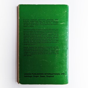 May include: Green book cover with white text. The book is titled "Occult Phenomena" and discusses topics like exorcism, witchcraft, spiritualism, and fortune telling. The back cover includes information about the author, George Tarieron, and his experience in the field.