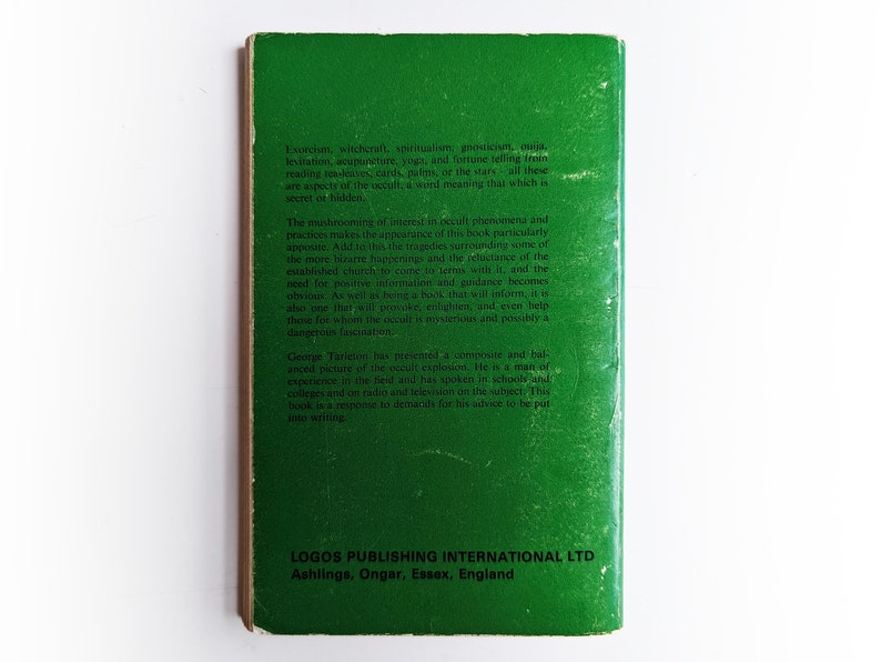 May include: Green book cover with white text. The book is titled "Occult Phenomena" and discusses topics like exorcism, witchcraft, spiritualism, and fortune telling. The back cover includes information about the author, George Tarieron, and his experience in the field.