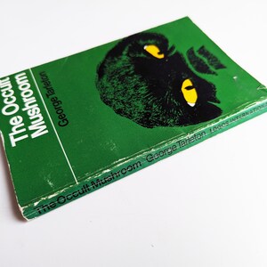 May include: A green paperback book titled "The Occult Mushroom" by George Tarleton. The cover features a black and white illustration of a mushroom with yellow eyes.