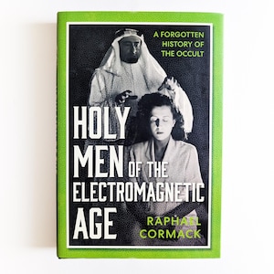 May include: A hardcover book titled Holy Men of the Electromagnetic Age: A Forgotten History of the Occult by Raphael Cormack. The cover features a black and white photograph of a person in a head covering and another person, with bright green borders.
