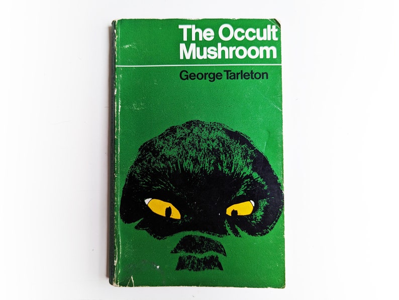 May include: A green book cover with the title "The Occult Mushroom" and the author "George Tarleton". The cover features a black and green illustration of a mushroom with yellow eyes.