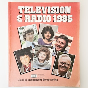 Könnte beinhalten: Ein rotes Buch mit dem Titel "Fernsehen & Radio 1985" mit einem Leitfaden für unabhängiges Rundfunk. Der Umschlag zeigt Fotos von sechs Personen.