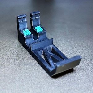 May include: A black 3D printed phone stand with the words "4D 3D" printed on the side.