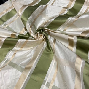 100% silk beautiful ivory base with olive sage green with ivory satin stripe plaids .  silk taffeta 54&quot; wide            Sold by the yard