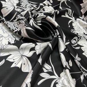 100% silk satin charmeuse digital print 54&quot; wide    Beautiful black base with white ivory color flowers design soft fabric 54” wide