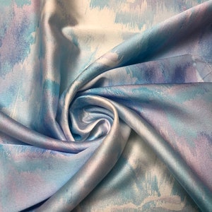 Beautiful ocean blue purple shades abstract design digital print on silky satin 54” wide. Sold by the yard. Best used for apparel