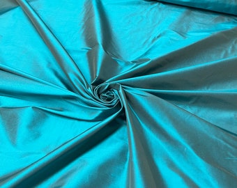 Beautiful bright Dark turquoise with brown Irredescent 100% silk taffeta 54” wide.  Best used for apparel and home Decore.  Sold by the yard