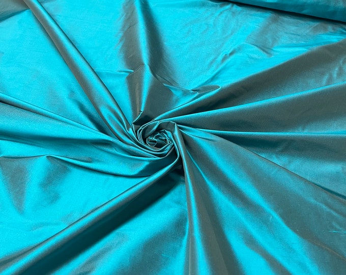 Beautiful bright Dark turquoise with brown Irredescent 100% silk taffeta 54” wide.  Best used for apparel and home Decore.  Sold by the yard