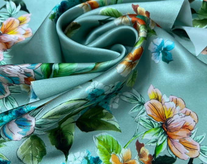 100% silk satin charmeuse digital print 54" wide    Beautiful Aqua mint base with yellow gold multi color floral design soft fabric 54” wide