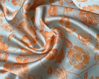 100% silk satin charmeuse digital print 54" wide    Beautiful Aqua mint green base with soft pastel orange color floral design 54” wide
