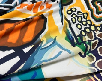 Beautiful black base with white base & orange purple colors abstract design silky satin 54” wide. Sold by the yard. Best used for apparel