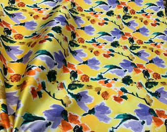 Mikado Zibelline printed fabric 54” wide.  Beautiful yellow base with multi color floral design beat used for apparel. Sold by the yard