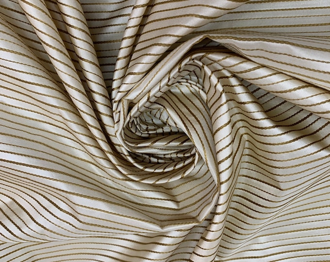 Beautiful beige with gold silk taffeta satin stripes 54” wide. Best used for home decor and apparel.  Sold by the yard