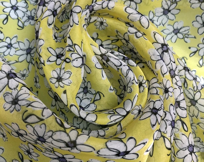 Satin face organza, also called Gazzar 54” wide. Beautiful lemon yellow base with white blackish little flowers design.