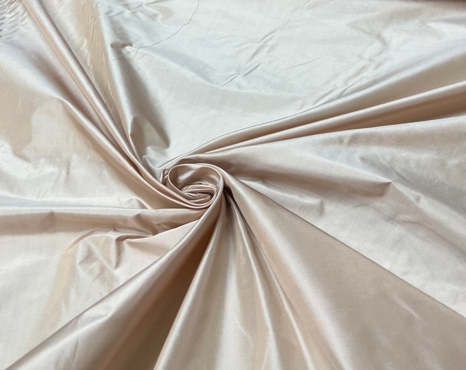 Beautiful bridal pink beige Irredescent 100% silk taffeta 54” wide.  Best used for apparel and home Decore.  Sold by the yard