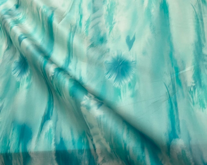 100% silk satin face organza, also called silk Gazzar 54” wide. Beautiful painting style Ombre design border style aqua green blue.