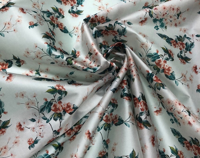 100% silk satin face organza, also called silk Gazzar 54” wide. Beautiful off white with burnt orange teal blue floral shades design.