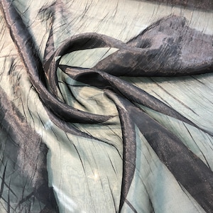 Peut inclure: Tissu noir transparent avec un reflet métallique. Le tissu est froissé et a une surface texturée.