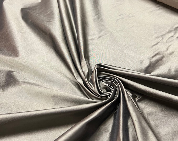 Beautiful charcoal Gray Irredescent 100% silk taffeta 54” wide.  Best used for apparel and home Decore.  Sold by the yard