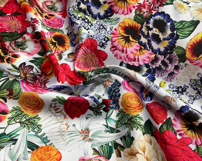 Mikado Zibelline printed fabric 54” wide.  Beautiful white base multi color mix flowers red yellow etc used for apparel.  Sold by the yard