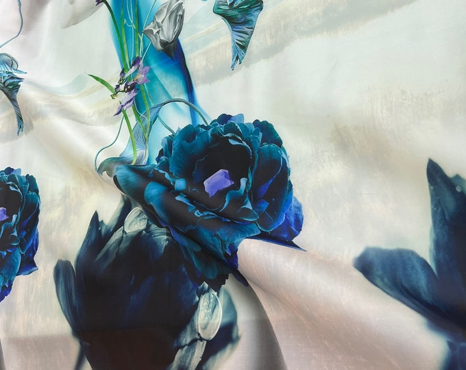 100% silk satin face organza, also called silk Gazzar 54” wide. Beautiful white blueish shades big floral border style design.