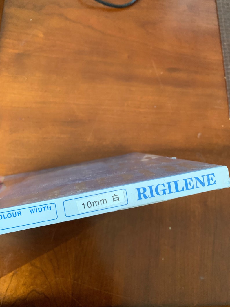 K&ouml;nnte beinhalten: Eine blaue und wei&szlig;e Schachtel mit dem Text "RIGILENE" und "10mm 白" darauf gedruckt. Die Schachtel hat auch die W&ouml;rter "COLOUR" und "WIDTH" aufgedruckt.