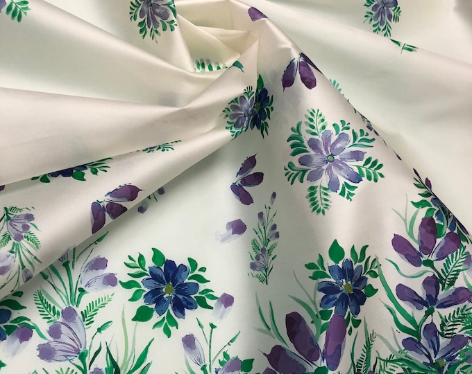 100% silk satin face organza, also called silk Gazzar 54” wide. Beautiful white with greens & purple shades floral border style design.