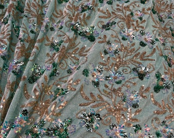 Velvet with sequence embroidered 45" wide   Beautiful mint green velvet with floral leaves sequence hunter green gold. sold by the yard